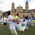 In this April 21, 2016 photo, Colombian singer Carlos Vives, left, celebrates a goal with a girl during a soccer match between youth and celebrities in the main square of Bogota, Colombia. The event was sponsored by the Development Bank for Latina America (CAF) to promote social inclusion and peaceful cohabitation. (AP Photo/Fernando Vergara)