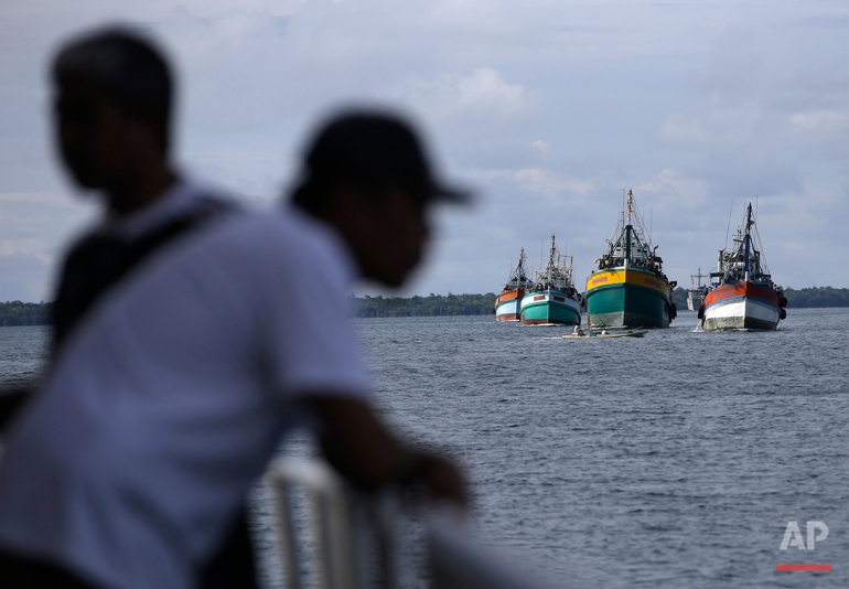 Fishing boats carrying recently rescued fishermen sail toward the town of Tual, Indonesia, Saturday, April 4, 2015. The rescued fishermen were among hundreds of migrant workers revealed in an Associated Press investigation to have been lured or tricked into leaving their countries and were brought to Indonesia to be forced to catch seafood. (AP Photo/Dita Alangkara)
