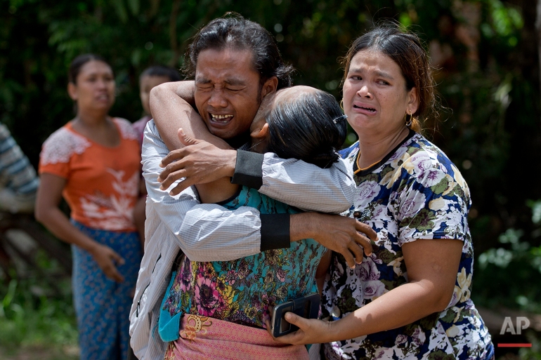 In this May 16, 2015, photo, former slave fisherman Myint Naing, left, is embraced by his mother Khin Than, second left, as his sister Mawli Than, right, is overcome with emotion after they were reunited after 22 years in their village in Mon State, Myanmar. Myint, 40, is among hundreds of former slave fishermen who returned to Myanmar following an Associated Press investigation into the use of forced labor in Southeast Asia’s seafood industry. (AP Photo/Gemunu Amarasinghe)