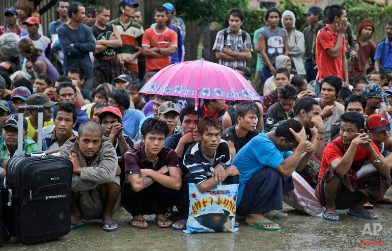 Burmese fishermen wait for their departure to leave the compound of Pusaka Benjina Resources fishing company in Benjina, Aru Islands, Indonesia, Friday, April 3, 2015. Hundreds of foreign fishermen on Friday rushed at the chance to be rescued from the isolated island where an Associated Press report revealed slavery runs rampant in the industry. Indonesian officials investigating abuses offered to take them out of concern for the men's safety. (AP Photo/Dita Alangkara)