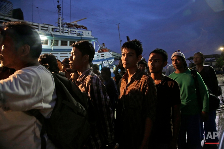 In this April 3, 2015 photo, Burmese fishermen prepare to board a boat during a rescue operation at the compound of Pusaka Benjina Resources fishing company in Benjina, Aru Islands, Indonesia. On Thursday, March 10, 2016, five Thai fishing boat captains and three Indonesians were sentenced to three years in jail for human trafficking in connection with slavery in the seafood industry. The suspects were arrested in the remote island village of Benjina in May 2015 after the abuse was revealed by The Associated Press in a report two months earlier. (AP Photo/Dita Alangkara)