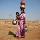 In this April 12, 2016 photo, a woman along with her son walks to get water from a communal well at Raichi Wadi village, 120 kilometers (75 miles) northeast of Mumbai, India. Decades of groundwater abuse, populist water policies and poor monsoons have turned vast swaths of central and western India into a dust bowl, driving distressed farmers to suicide or menial day labor in the cities. (AP Photo/Rafiq Maqbool)
