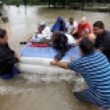 Residents use an air mattress to float on floodwaters as they evacuate their flooded apartment complex Monday, April 18, 2016, in Houston. Storms have dumped more than a foot of rain in the Houston area, flooding dozens of neighborhoods and forcing the closure of city offices and the suspension of public transit. (AP Photo/David J. Phillip)