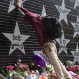 Terrance May, a musician who goes by the name May Millions, takes a moment at a growing memorial outside First Avenue, a Minneapolis club where Prince filmed a large portion of his classic movie "Purple Rain" and recorded several songs on the accompanying album in Minneapolis, Thursday, April 21, 2016. (AP Photo/Kevin Burbach)