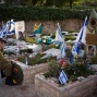 An Israeli soldier visits the grave of his friend on the Memorial Day eve commemorating fallen soldiers, at the military cemetery at Mount Hertzl in Jerusalem, Tuesday, May 10, 2016. Israel will mark the annual Memorial Day in remembrance of soldiers who died in the nation's conflicts, beginning at dusk Tuesday until Wednesday evening. (AP Photo/Oded Balilty)