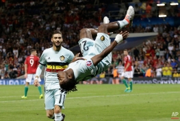 Belgium's Michy Batshuayi is airborne as he celebrates after scoring his side's second goal during the Euro 2016 round of 16 soccer match between Hungary and Belgium, at the Stadium municipal in Toulouse, France, Sunday, June 26, 2016. (AP Photo/Petr David Josek)