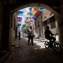 Palestinians walk under show umbrellas used to decorate a street in the Old City of the West Bank town of Nablus, Saturday, June 4, 2016. (AP Photo/Majdi Mohammed)