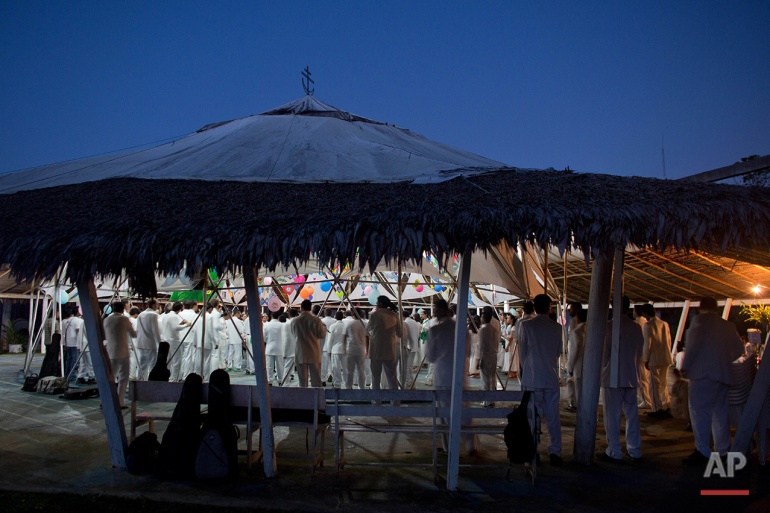 In this June 23, 2016 photo, members of church of the doctrine of Holy Daime stand during a religious service, at dawn, in Ceu do Mapia, Amazonas state, Brazil. Most services last all night and into the morning. (AP Photo/Eraldo Peres)